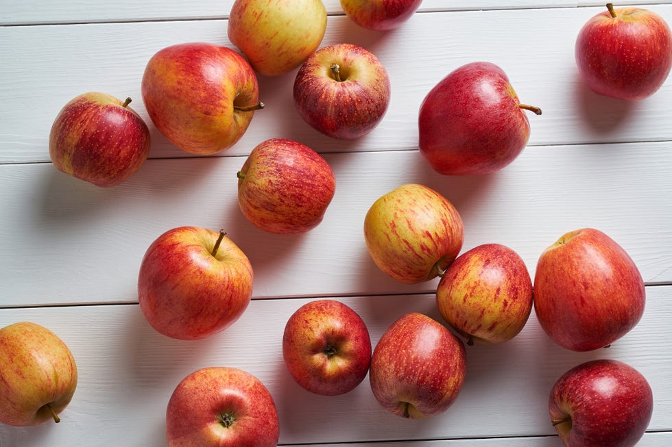 red ripe apples on a white wooden background fruit on the kitchen table cultivation of organic farm products the concept of vegetarian, vegan, raw food and diet from farm to table, harvest vegetable food a sustainable lifestyle