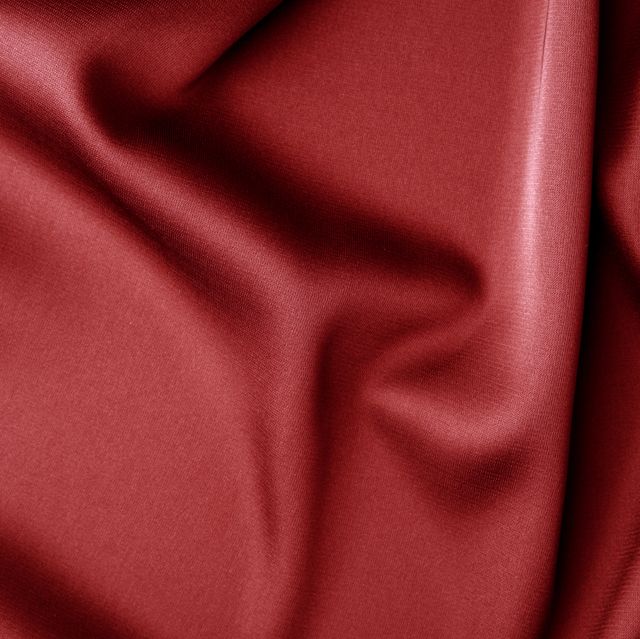 red silk silky satin fabric wavy shiny luxurious shine drapery background, material texture full frame