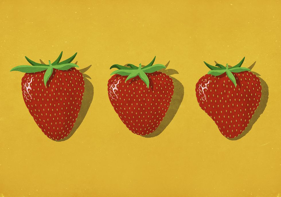 red strawberries on vibrant yellow background