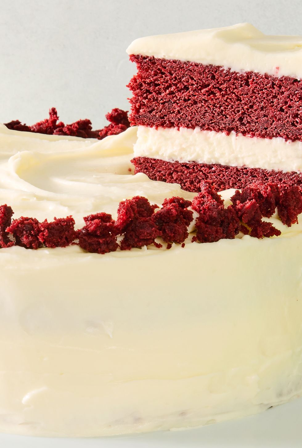 layered red velvet cake with cream cheese icing and pieces of cake
