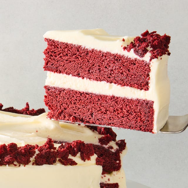 layered red velvet cake with cream cheese icing and pieces of cake