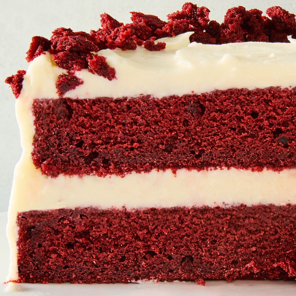 layered red velvet cake with cream cheese icing and pieces of cake