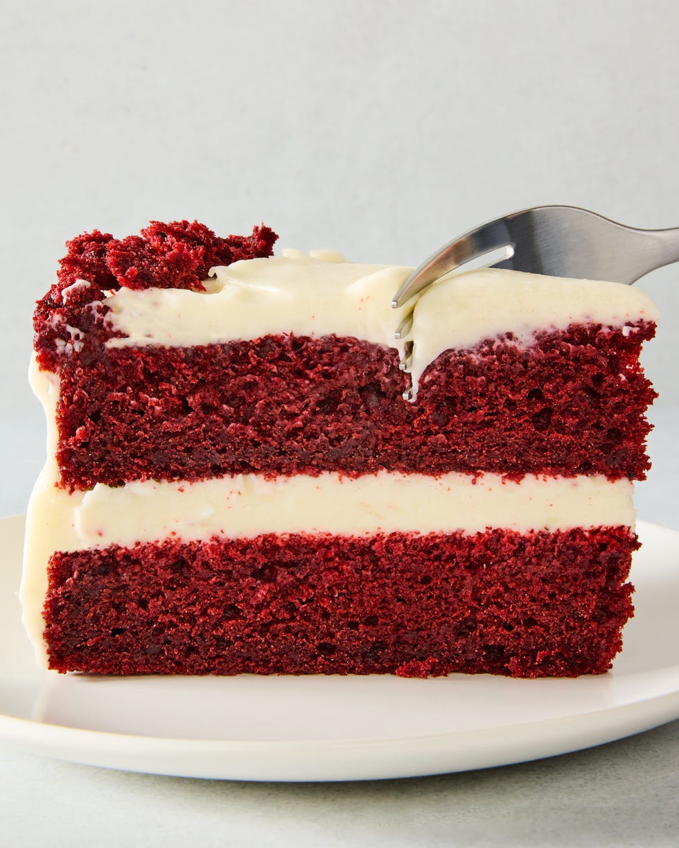 layered red velvet cake with cream cheese icing and pieces of cake