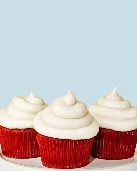 a close up of red velvet cupcakes with white frosting
