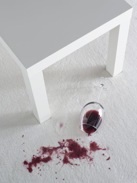 Red wine spilling on white carpet