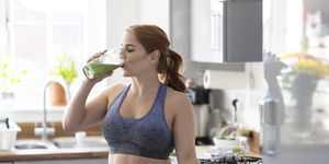 redhead woman drinking healthy milkshake after working out at home