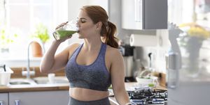 redhead woman drinking healthy milkshake after working out at home