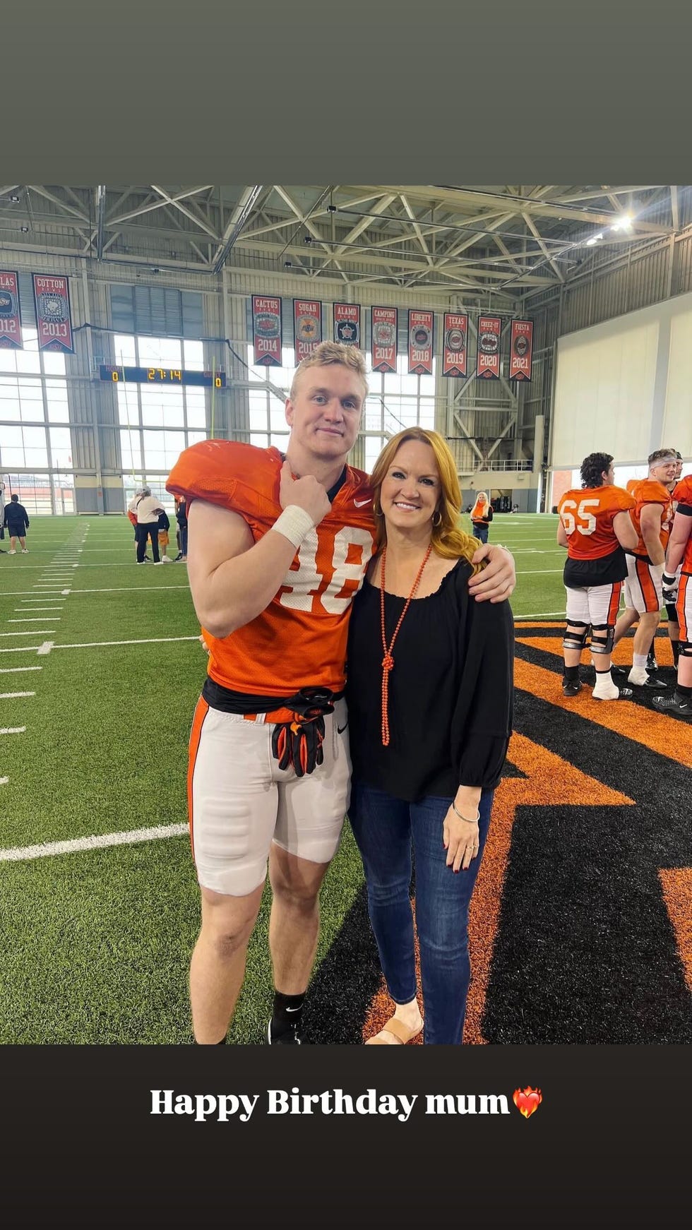 a football player poses with a woman during a birthday celebration