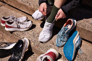 a person sitting on the ground with old running shoes