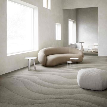 curved sofa and curvy carpet in neutral room