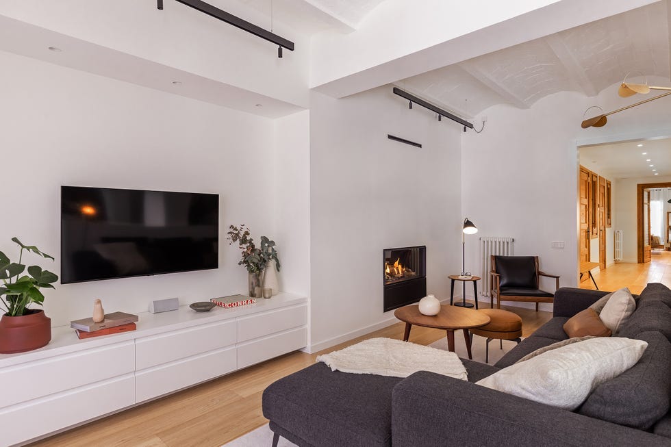 salón abierto moderno con paredes blancas y sofá gris con chaise longue