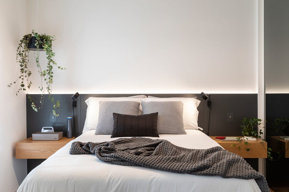 dormitorio moderno con cabecero negro y mesillas flotantes de madera
