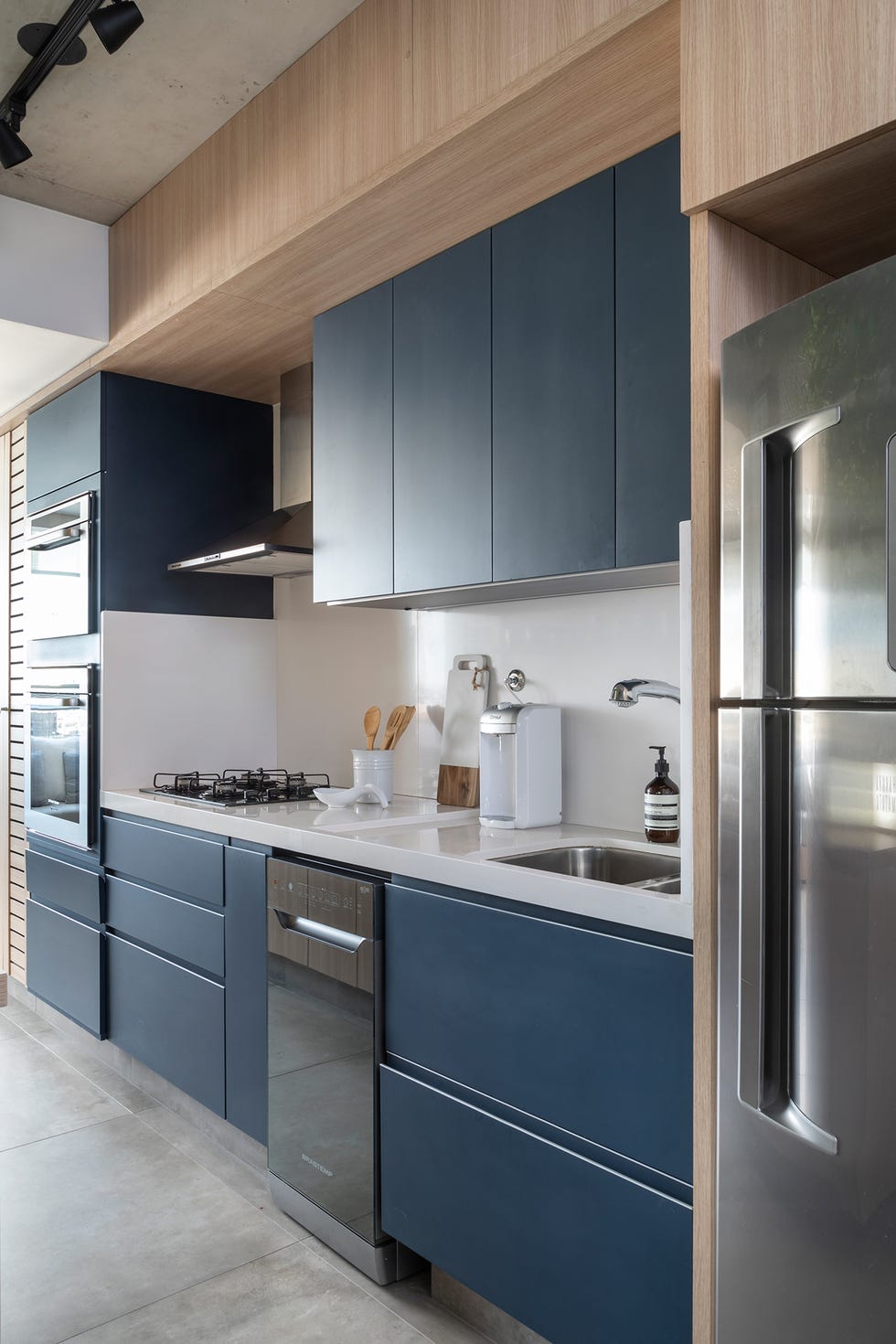cocina moderna con muebles lacados en azul sin tiradores y encimera blanca