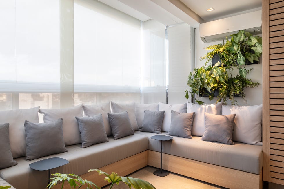 sofá gris en forma de u y baldas decoradas con plantas