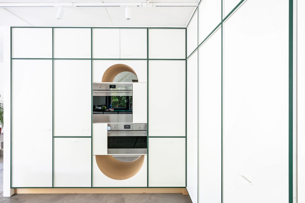 armarios de cocina en blanco con juntas verdes y horno y microondas en columna