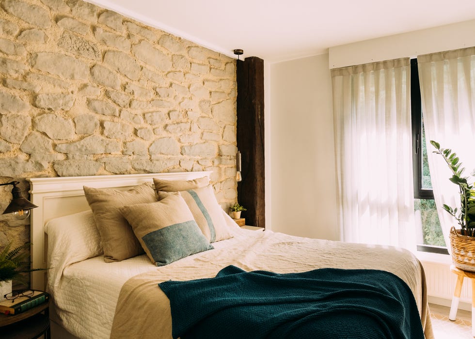 dormitorio rústico con paredes de piedra
