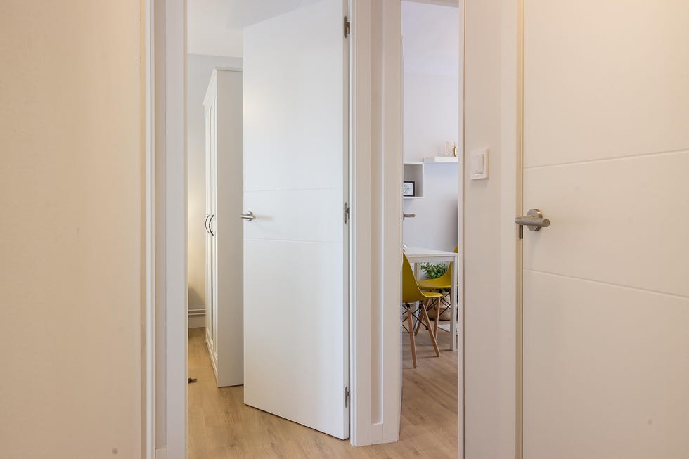 pasillo con puertas y paredes blancas