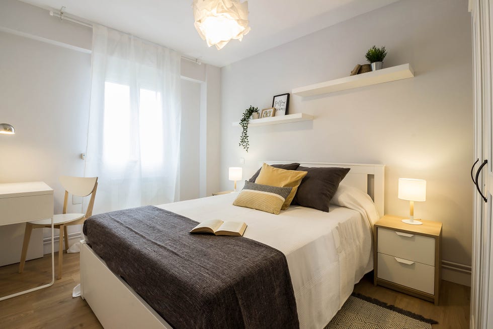 dormitorio moderno decorado en blanco con mobiliario nórdico