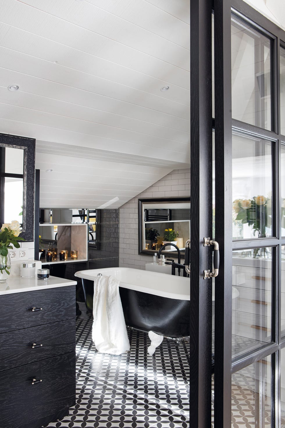 baño decorado en blanco y negro con bañera con patas de estilo clásico