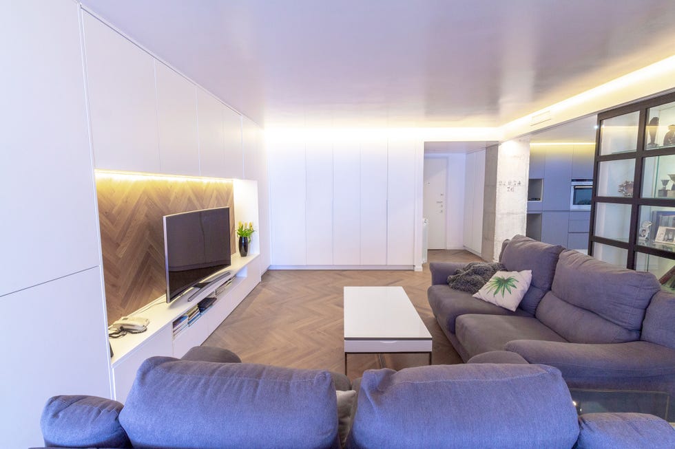 Salón con dos sofás y armarios empotrados de color blanco