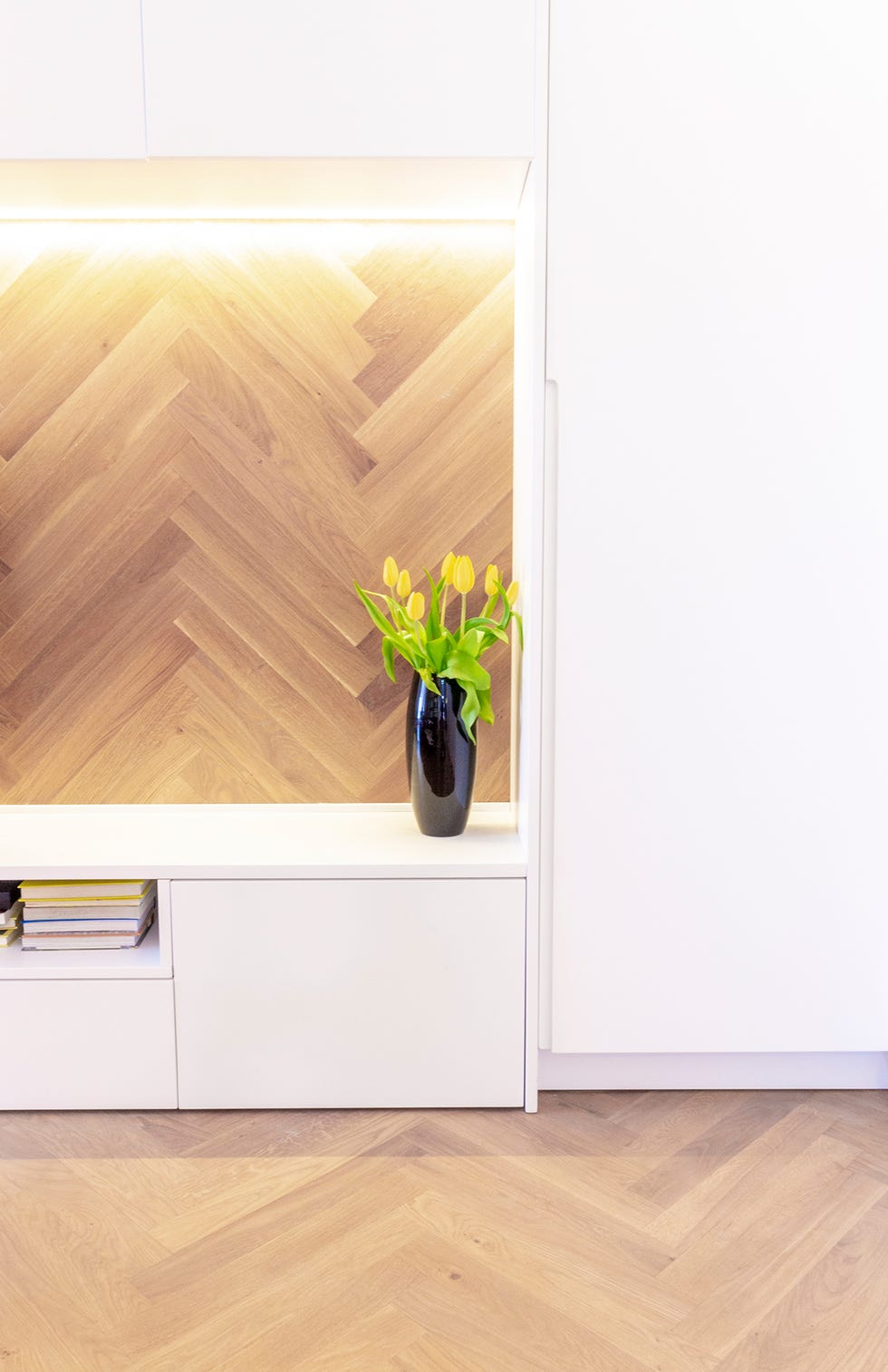 Vista de un armario del salón y revestimiento de la pared con madera en espiga