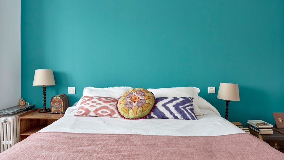 dormitorio con pared del cabecero pintada en azul turquesa