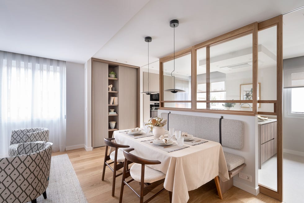cocina separada del comedor por un cerramiento acristalado con puertas correderas y perfilería de madera