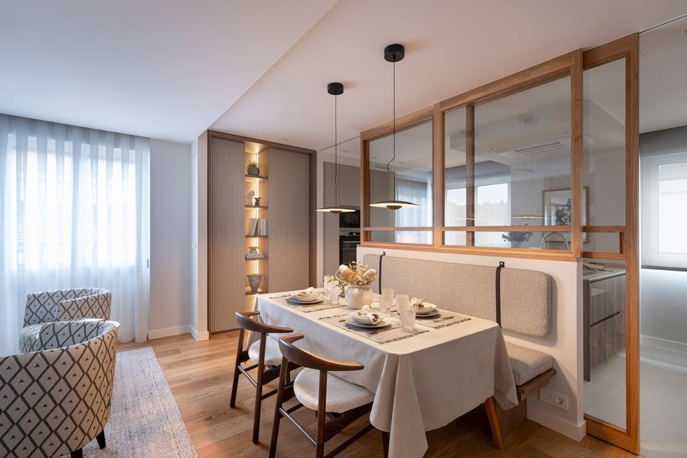 cocina separada del comedor por un cerramiento acristalado con puertas correderas y perfilería de madera