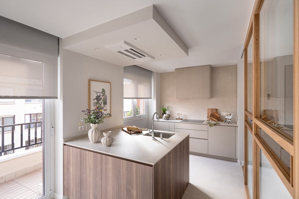 cocina con península y cerramiento de cristal con perfilería de madera