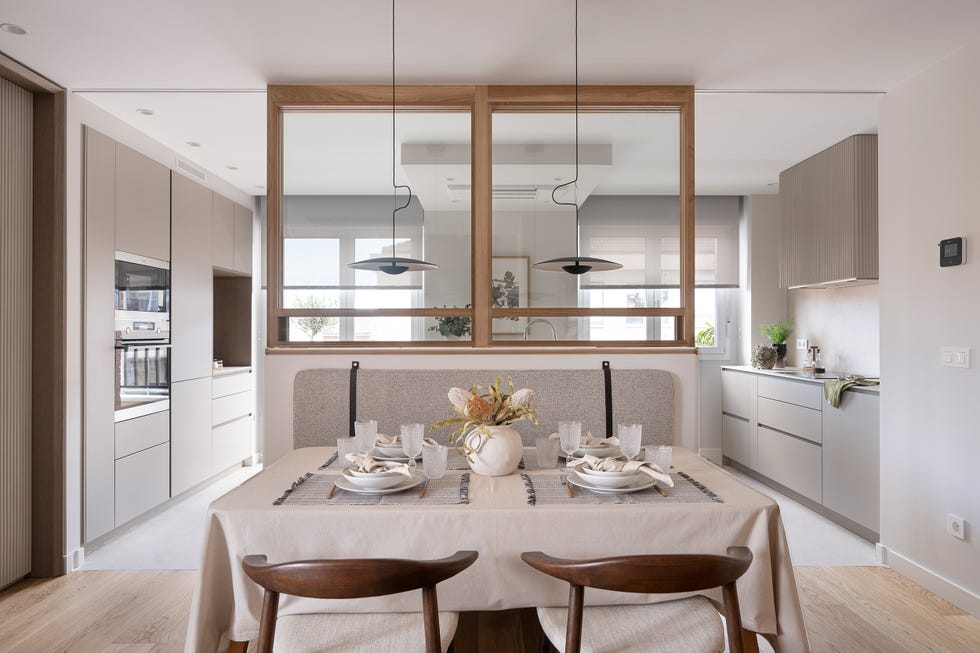 cocina separada del comedor por un cerramiento acristalado con puertas correderas y perfilería de madera