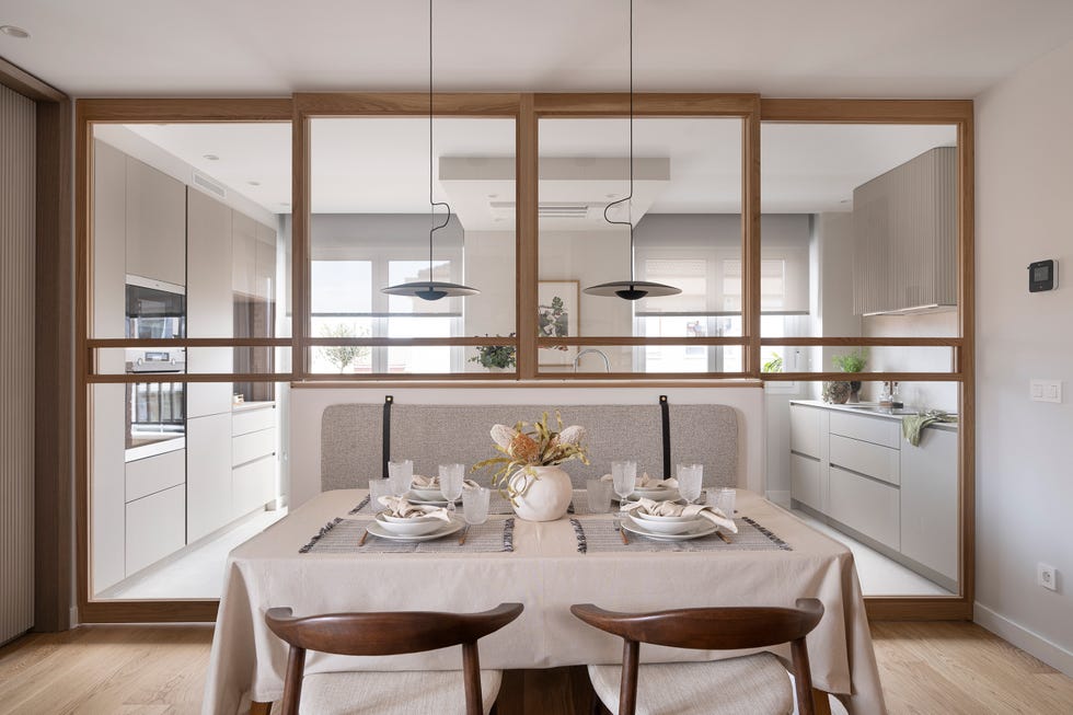 cocina separada del comedor por un cerramiento acristalado con puertas correderas y perfilería de madera