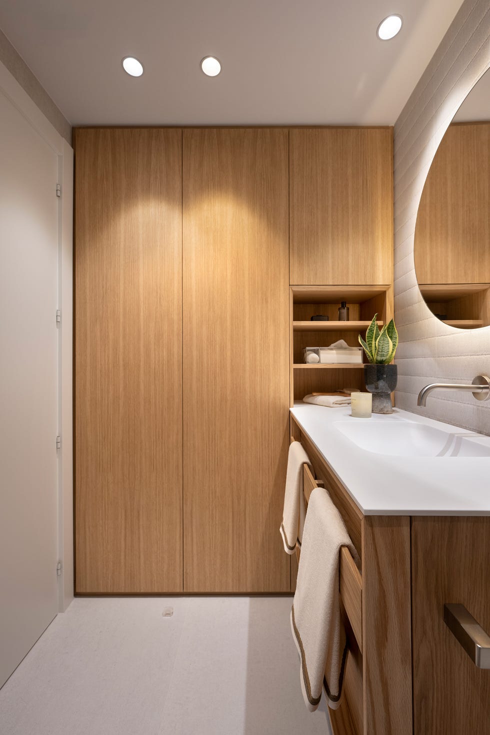 baño con armario de madera de suelo a techo