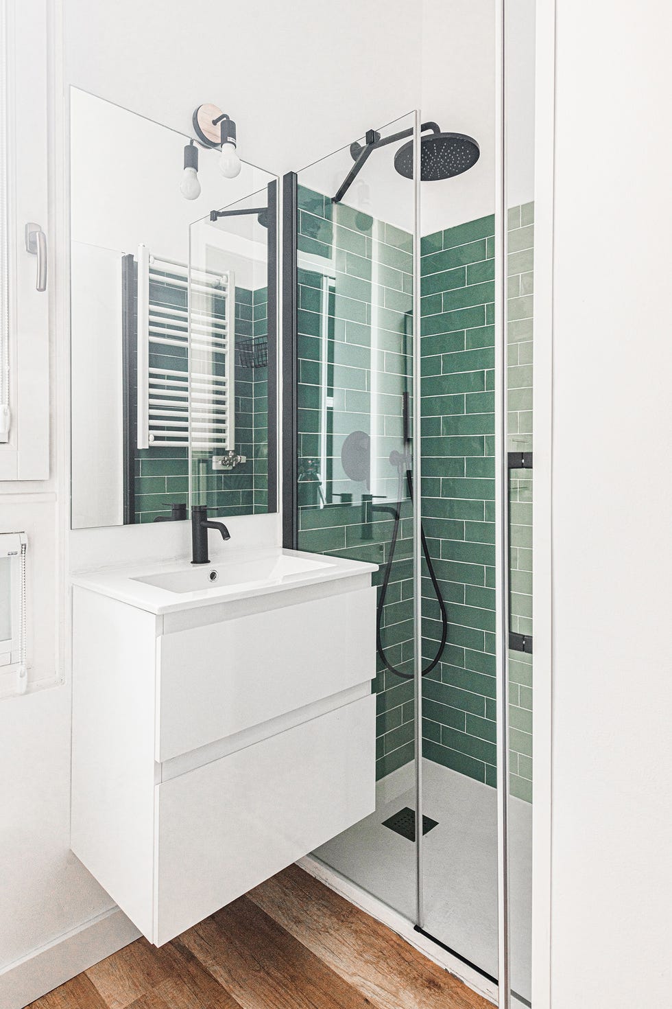 baño con mueble blanco volado y ducha con azulejos verdes