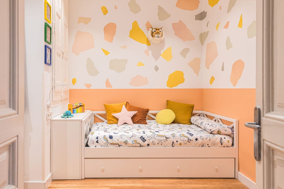 habitación infantil con cama nido blanca y pared de color naranja con papel pintado