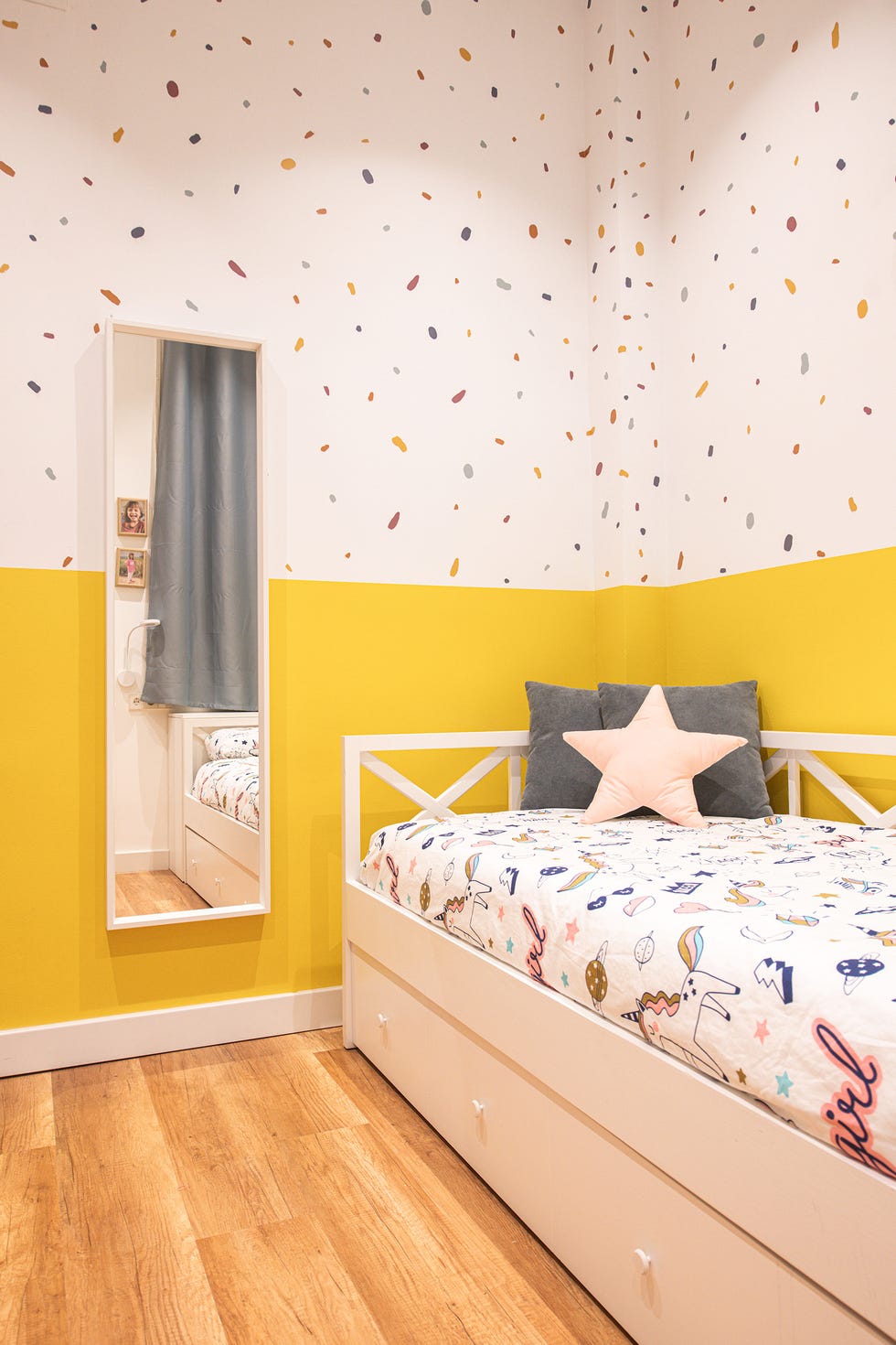 habitación infantil con cama nido blanca y pared de color amarillo con papel pintado