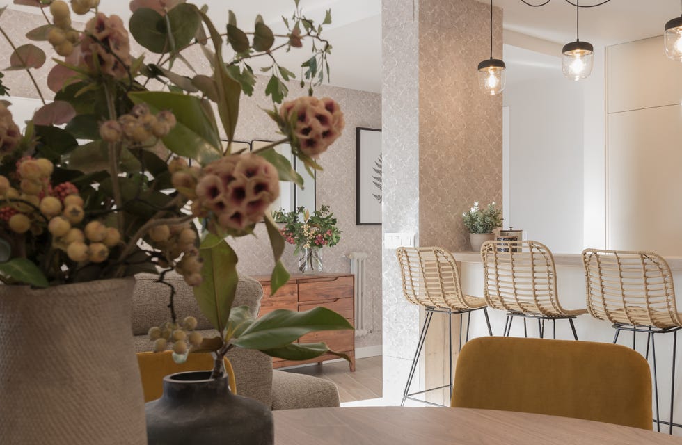 cocina abierta al salón con barra y tres taburetes