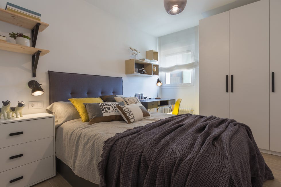 dormitorio juvenil con cabecero gris acolchado y muebles blancos