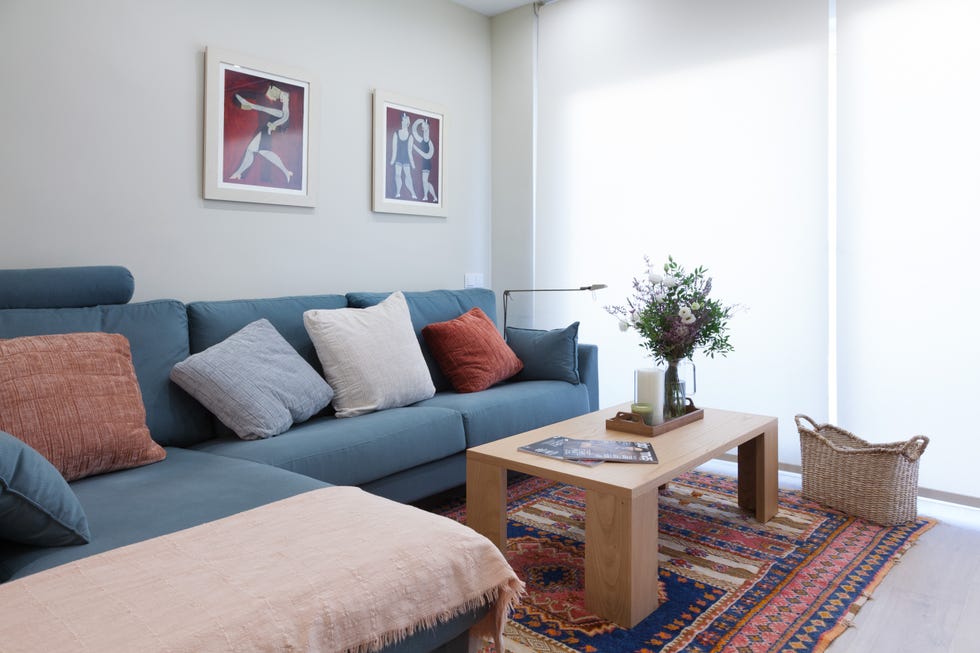 salón comedor con sofá con chaise longue azul y mesa de centro de madera