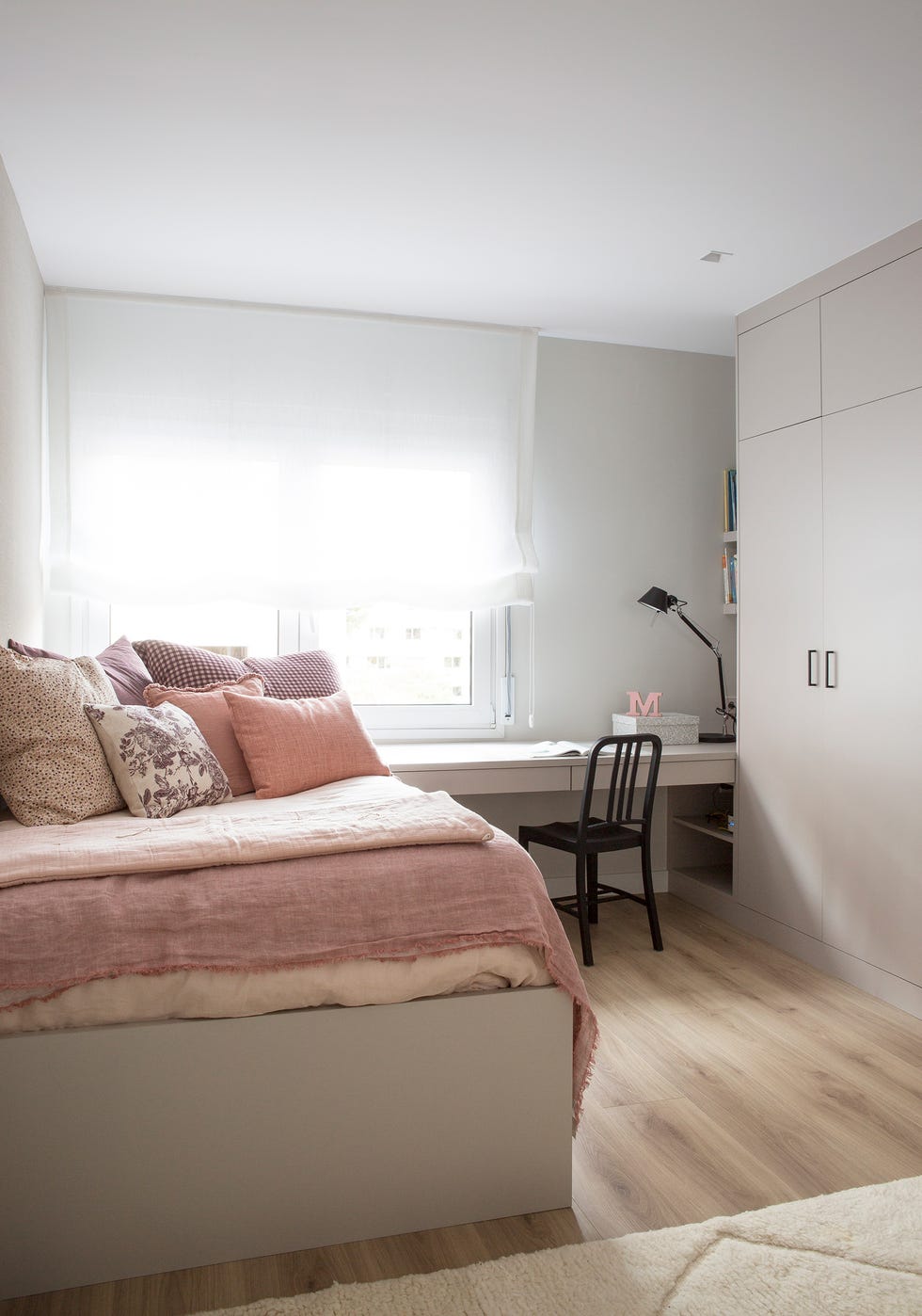 habitación juvenil moderna con escritorio decorada en color gris con ropa de cama rosa