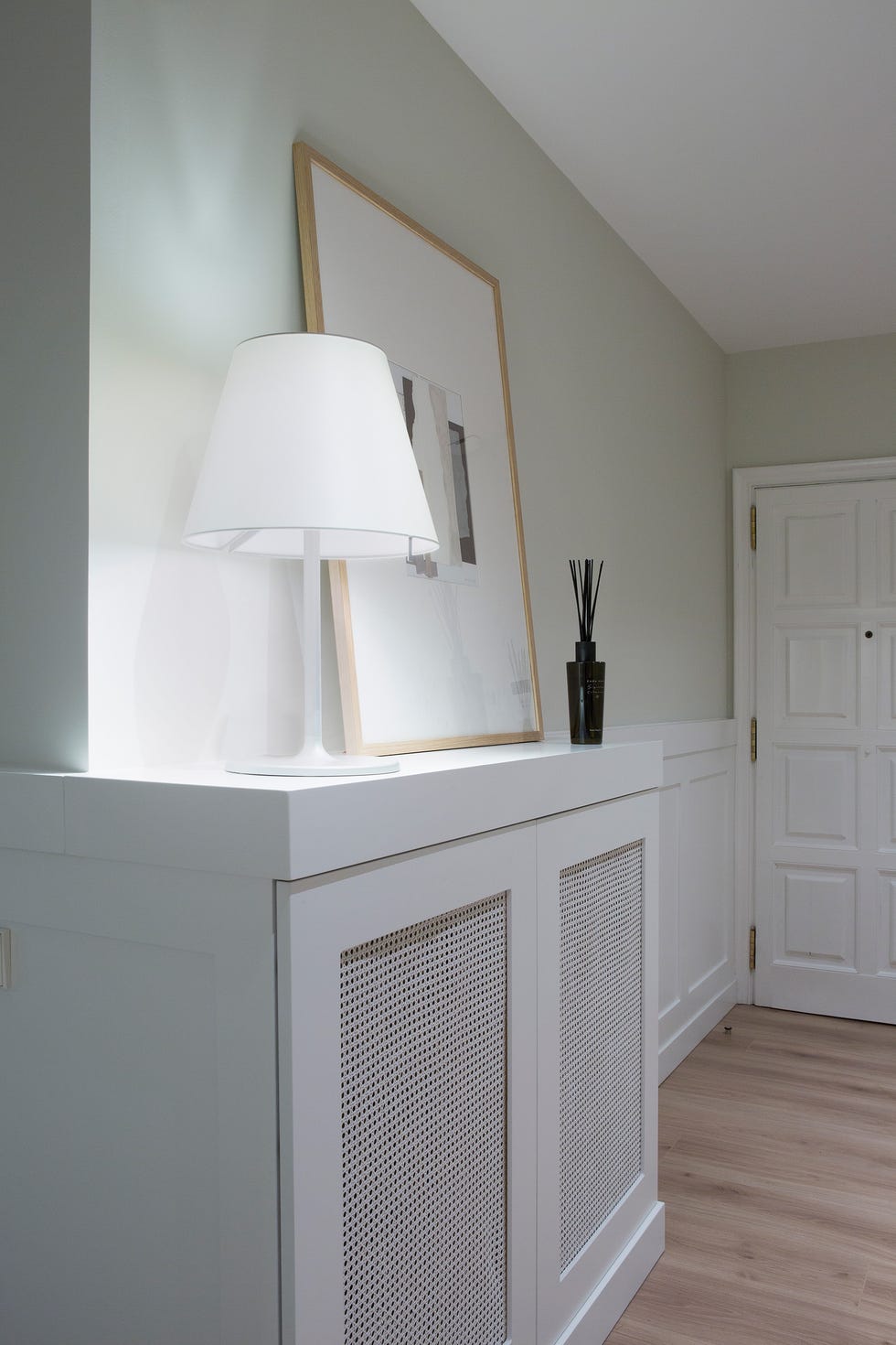 recibidor con mueble blanco y puertas de rejilla