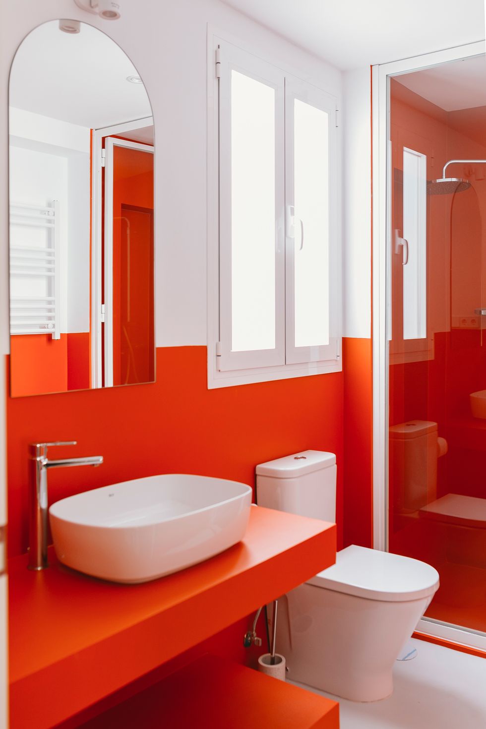 baño moderno con ducha de obra decorado en naranja intenso y blanco