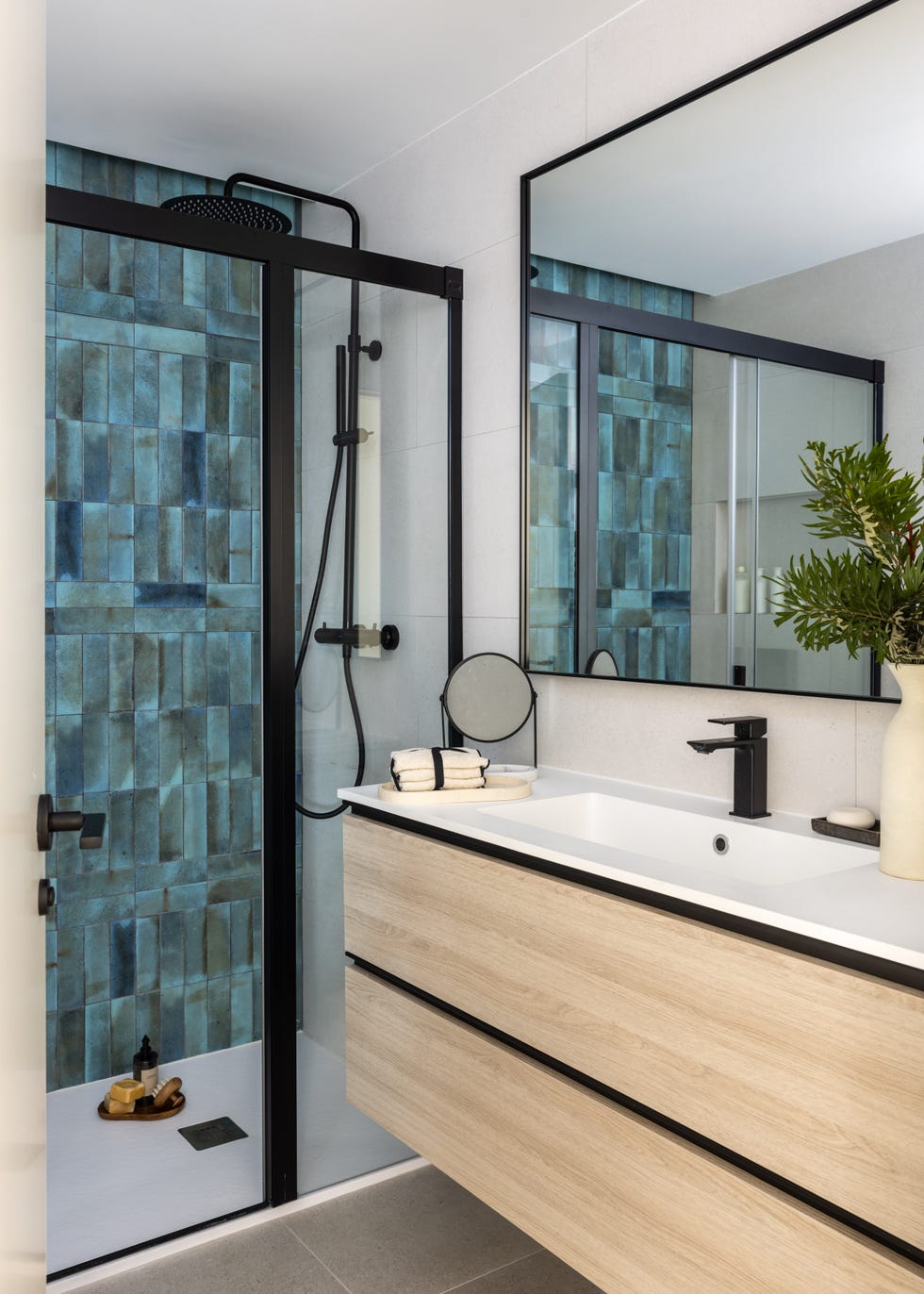 baño con mueble de madera volado y ducha con azulejos turquesa