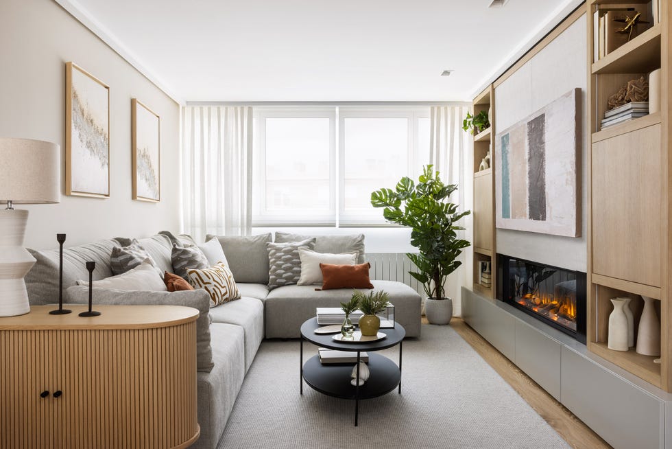 salón con sofá con chaiselongue gris y chimenea