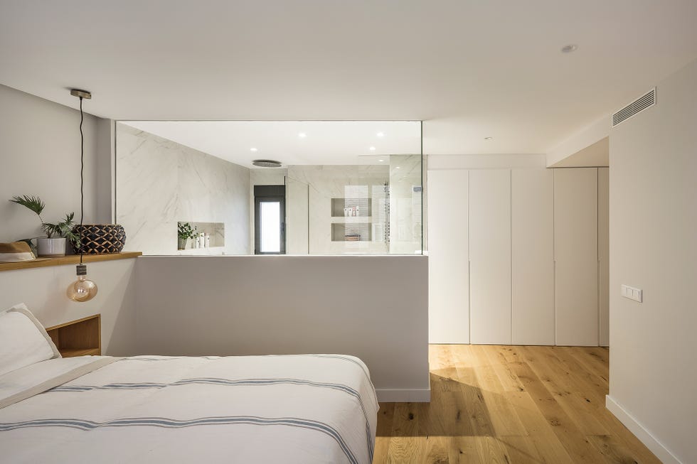 dormitorio con baño en suite y armarios empotrados en color blanco