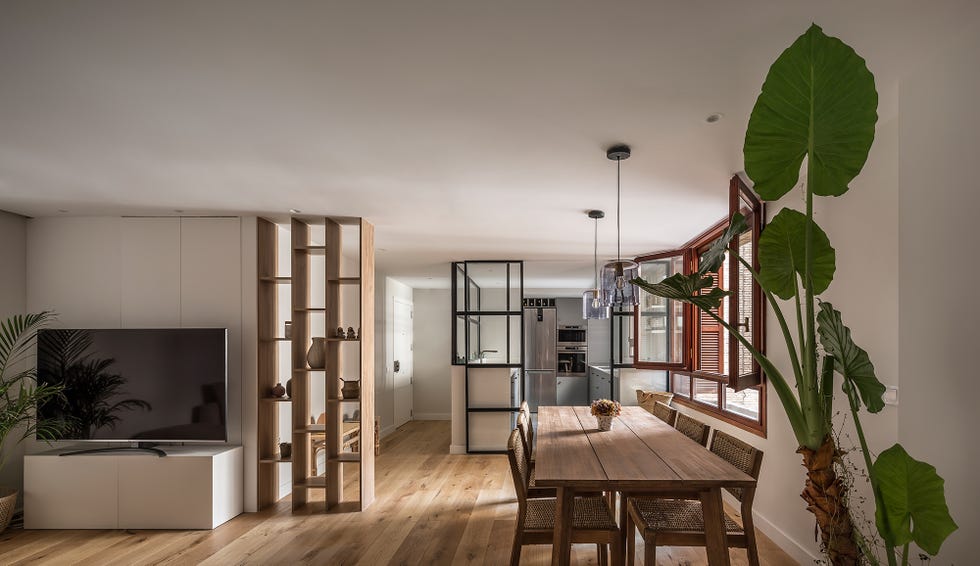 comedor con mesa de madera y sillas de fibras abierto a la cocina