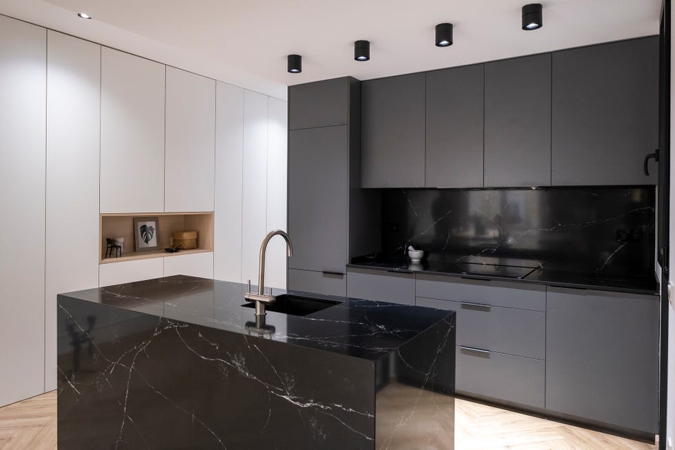 Cocina abierta con isla central diseñada en mármol negro