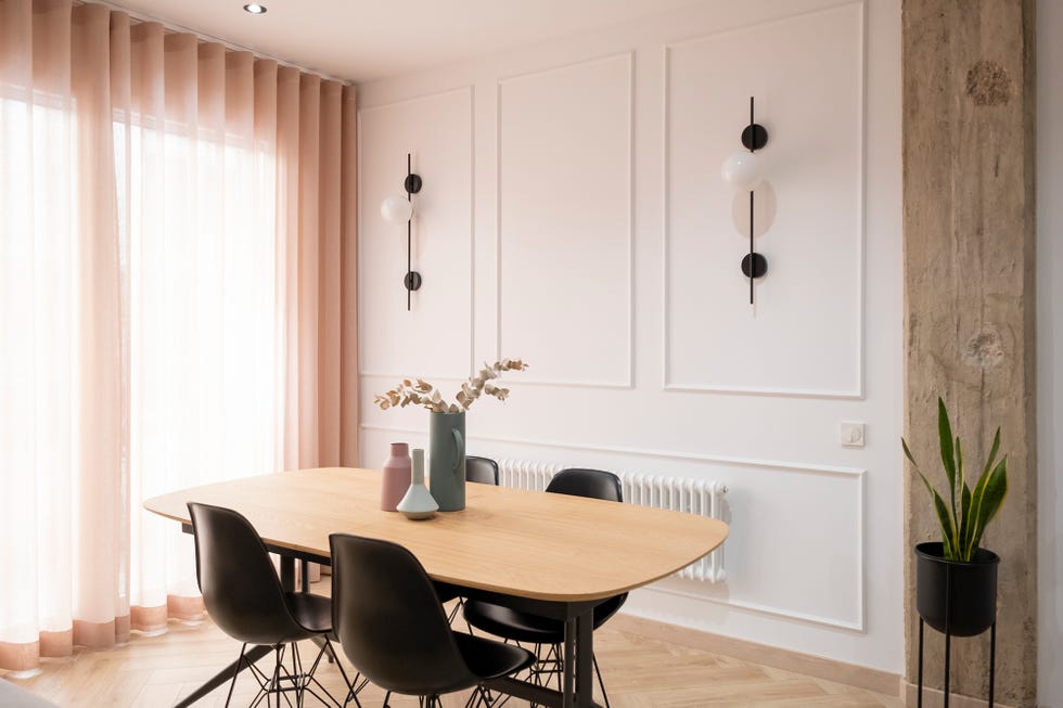 Comedor con pilares de hormigón decorado en tonos dulces y suelo de espiga