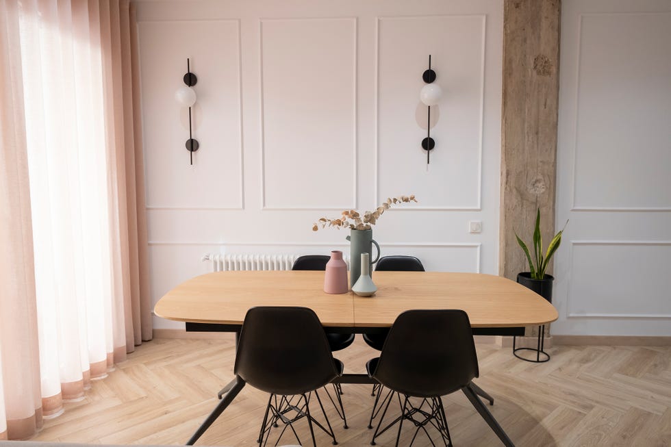 Comedor con pilares de hormigón decorado en tonos dulces y suelo de espiga