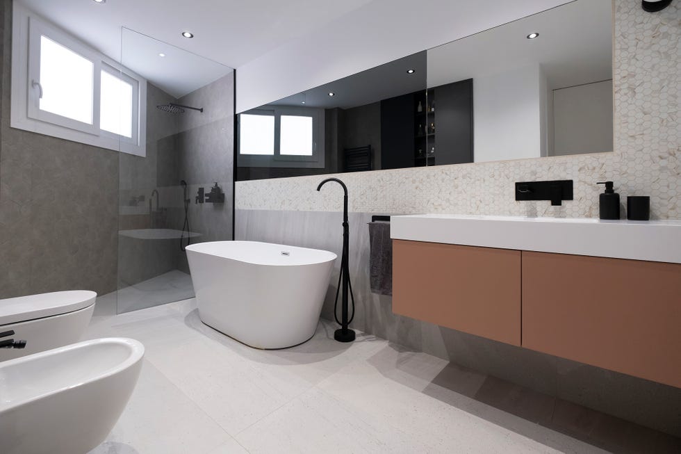 Baño con bañera exenta y ducha de obra decorado en tonos neutros