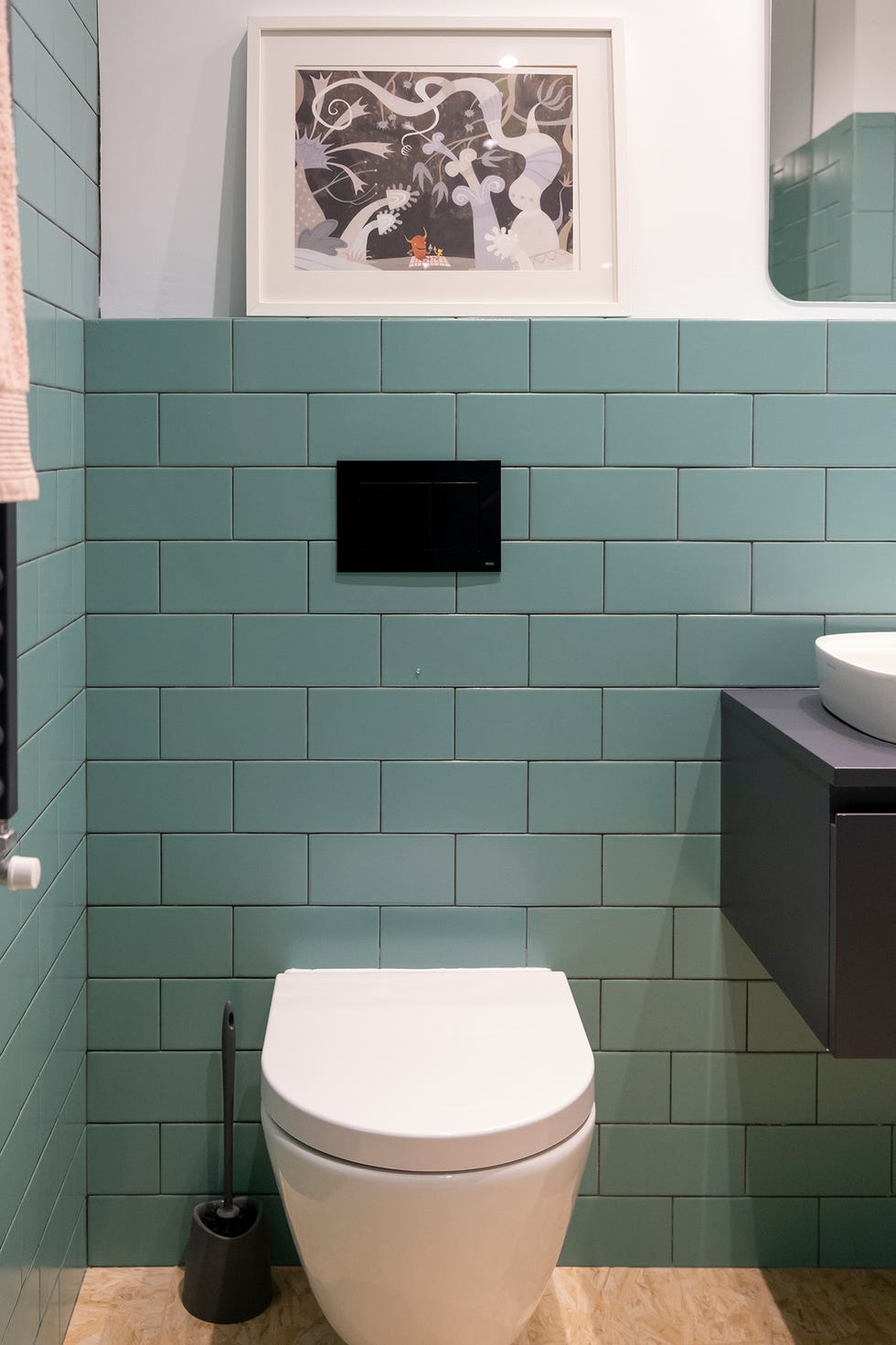 Baño decorado con pequeñas baldosas verdes biseladas y un rejunte gris